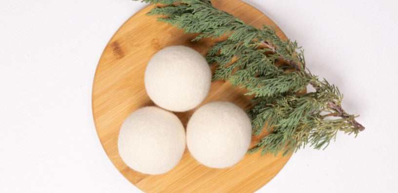 A couple wool dryer balls on top of small circle table.