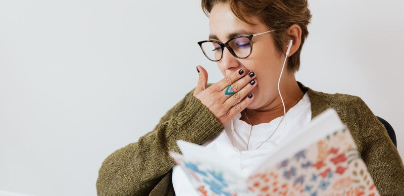 A woman is yawning while listening to music.