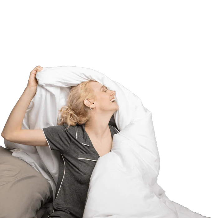 A woman relaxing in bed, surrounded by a Luxury Down Alternative Comforter, enjoying a moment of peace.