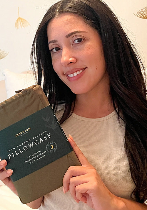 A happy customer is holding a packaged pair of 100% Bamboo pillowcases.