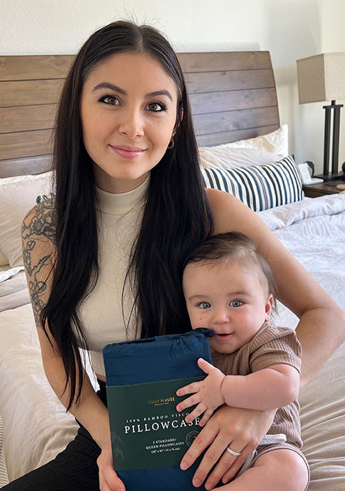 A mother and her baby holding a packaged pair of 100% Bamboo pillowcases.