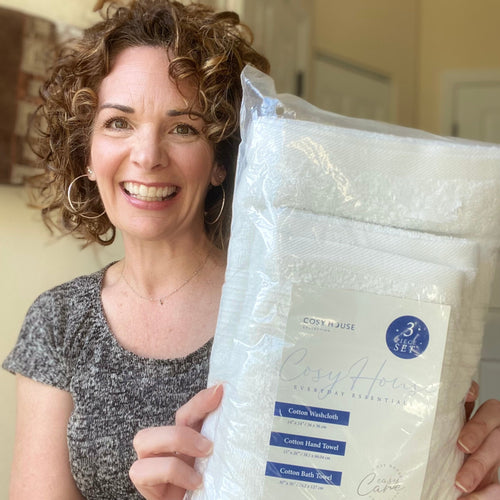 A smiling customer displays her packaged Essential Cotton Towel set.