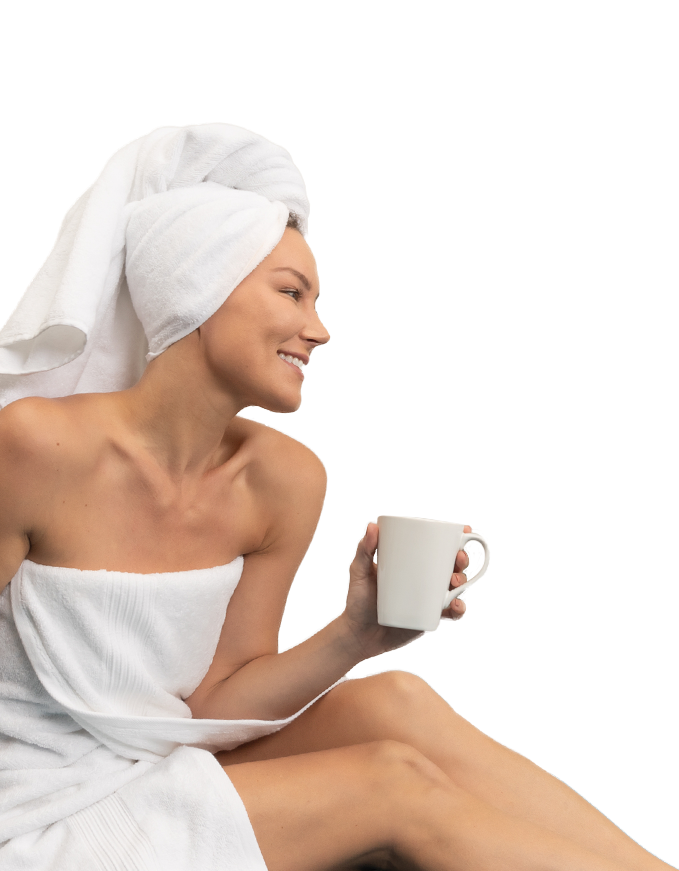 A woman wrapped in a towel holds a steaming cup of coffee, embodying a peaceful morning moment.