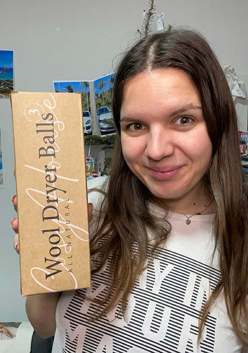 A customer displaying her packaged Cosy House Collection All Natural Wool Dryer Balls.