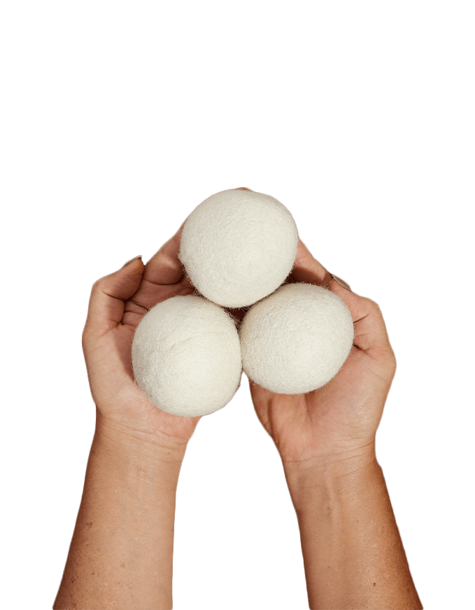 Both hands holding three All Natural Wool Dryer Balls.