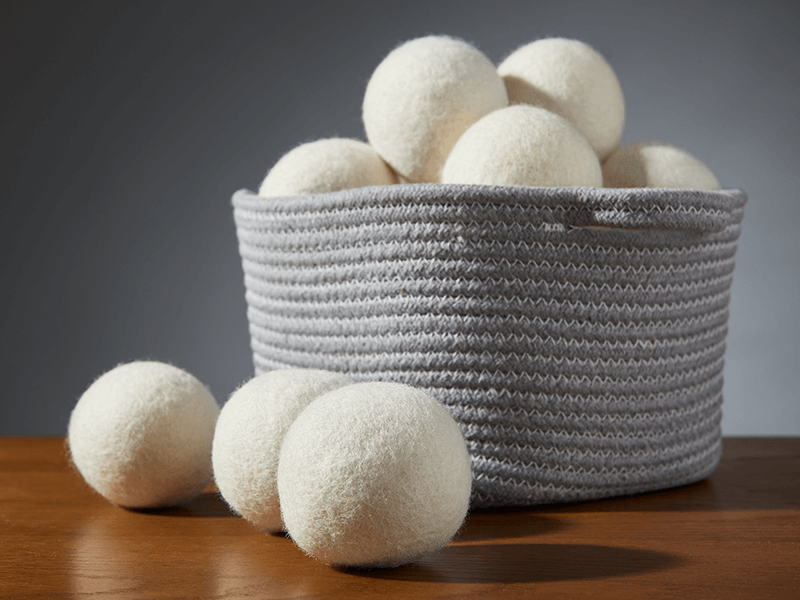 A small basket filled of All Natural Wool Dryer Balls.