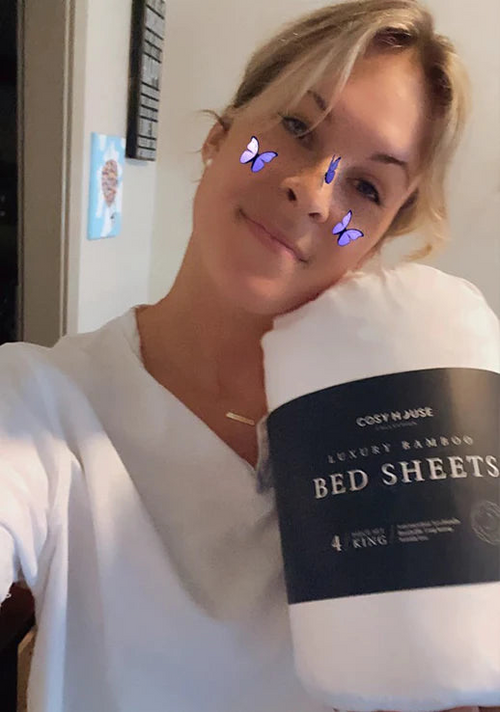 Another happy customer holding a packaged set of Cosy House Collection’s Luxury bed sheets.